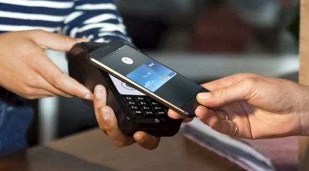 A close up of a person using their Android device to purchase via pay wave