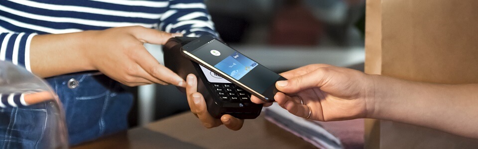 A close up of a person using their Android device to purchase via pay wave