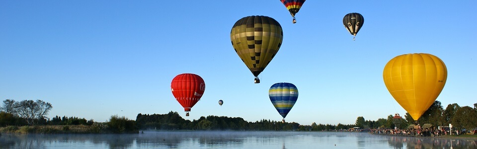 Landscape image of hot multiple hot air balloons in the sky