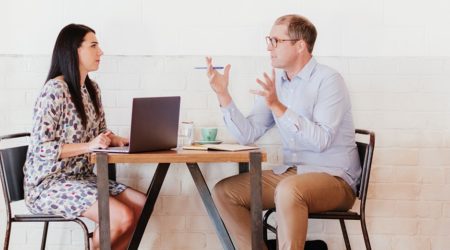 Business woman and business man sitting at a cafe conversing