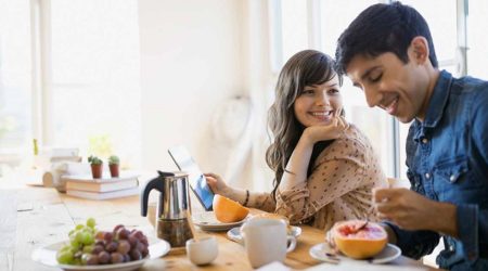 Young woman and man eating breakfast together.