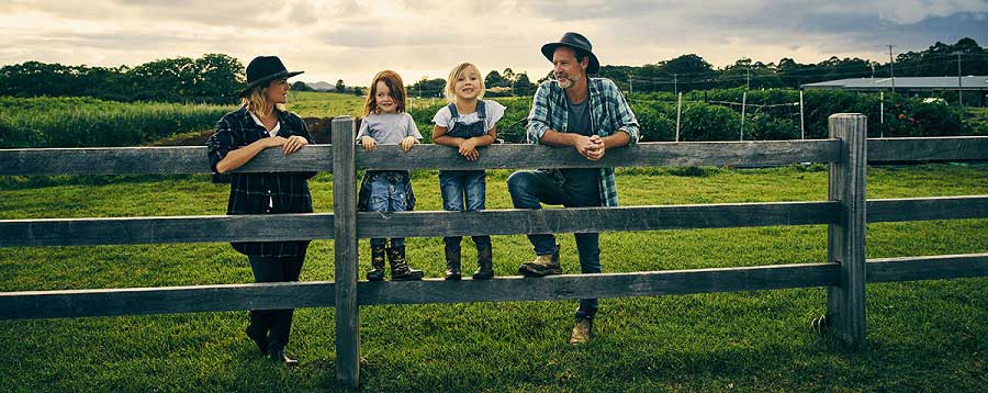 Full length shot of a family of four standing on their farm