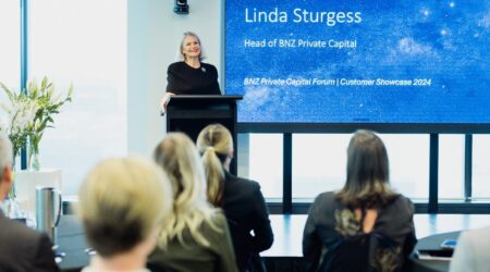 Linda Sturgess standing at podium presenting to a group.